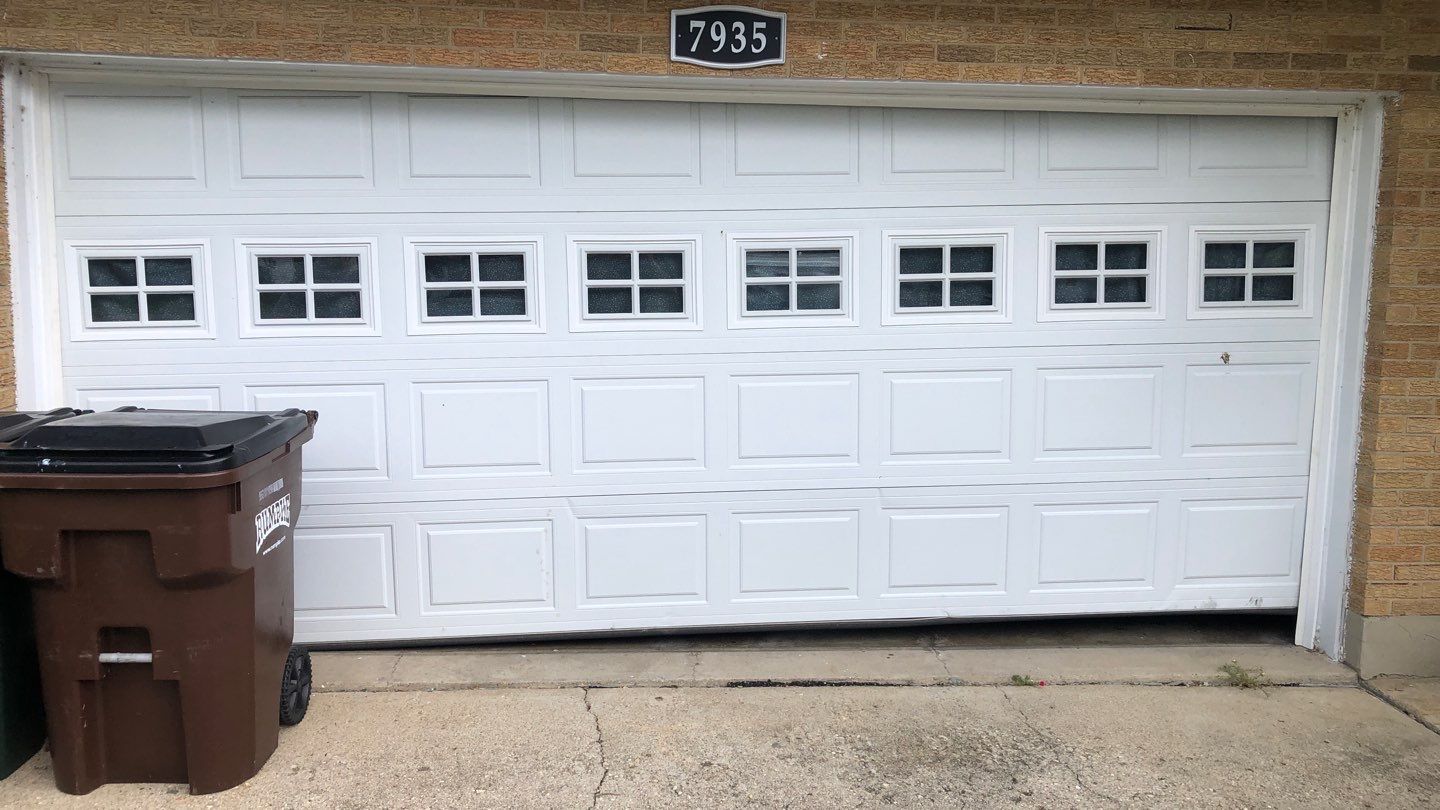 Garage door technician inspecting a garage door that reverses before closing