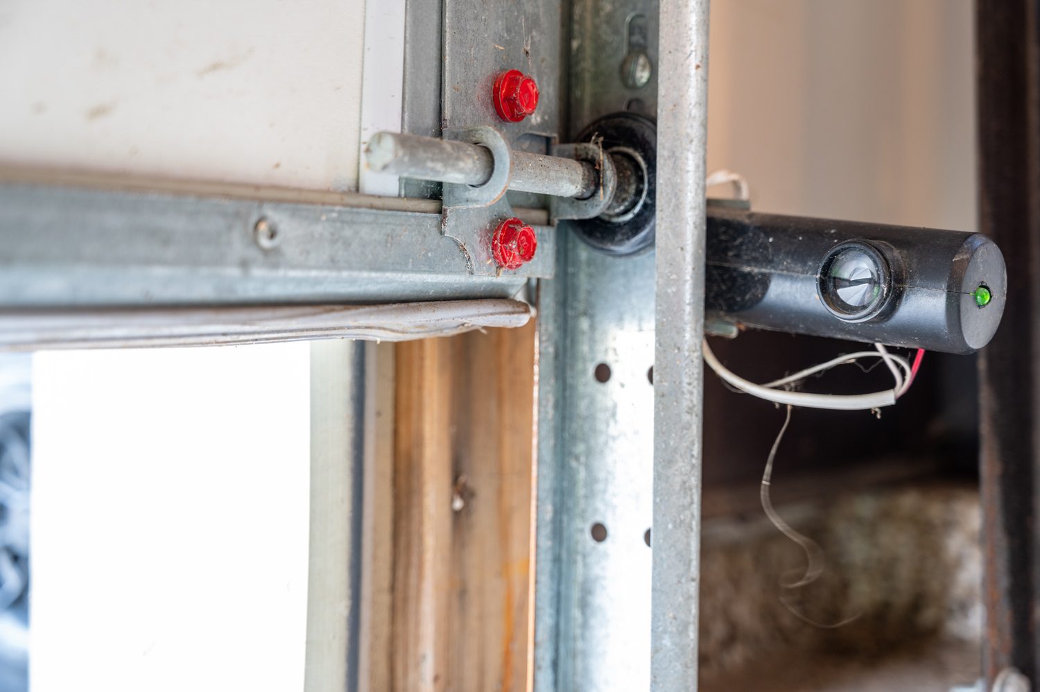 Garage door technician inspecting garage door rollers and track system