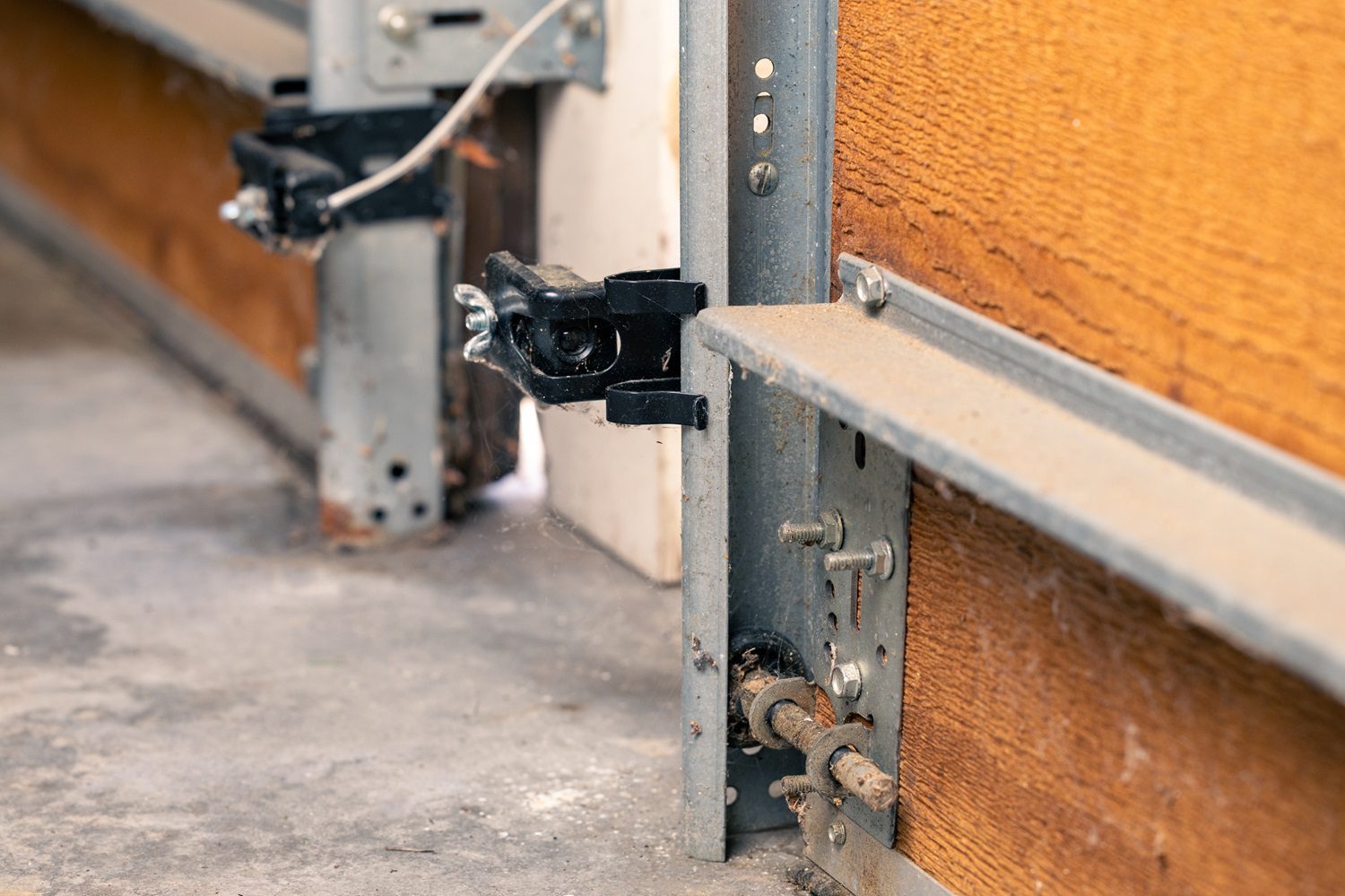 Garage door technician inspecting safety sensors on a residential garage door in Dayton Ohio
